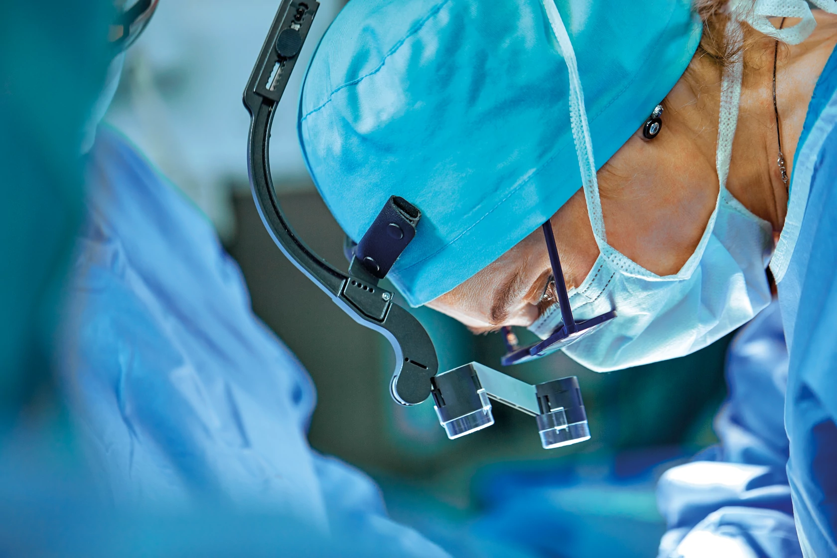 Close-up of the face of a surgeon wearing magnifying glasses.